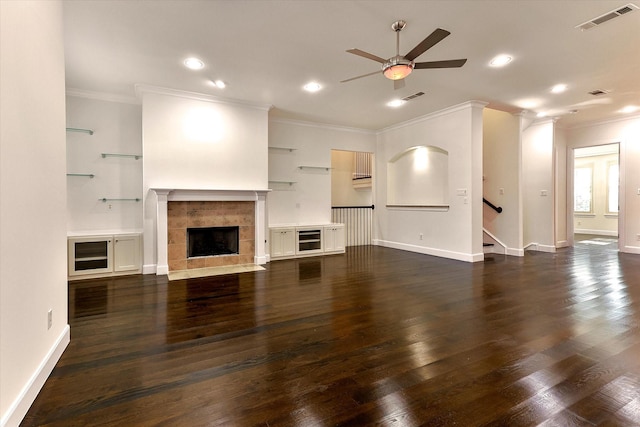 unfurnished living room with a fireplace, dark wood-type flooring, ceiling fan, and ornamental molding