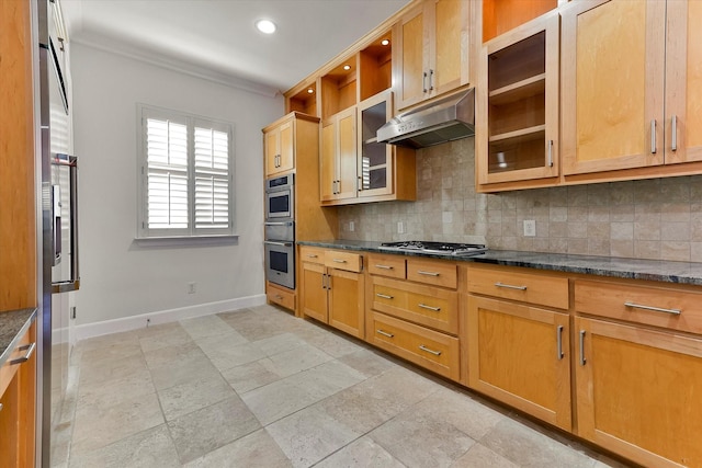 kitchen with appliances with stainless steel finishes, dark stone countertops, crown molding, and decorative backsplash