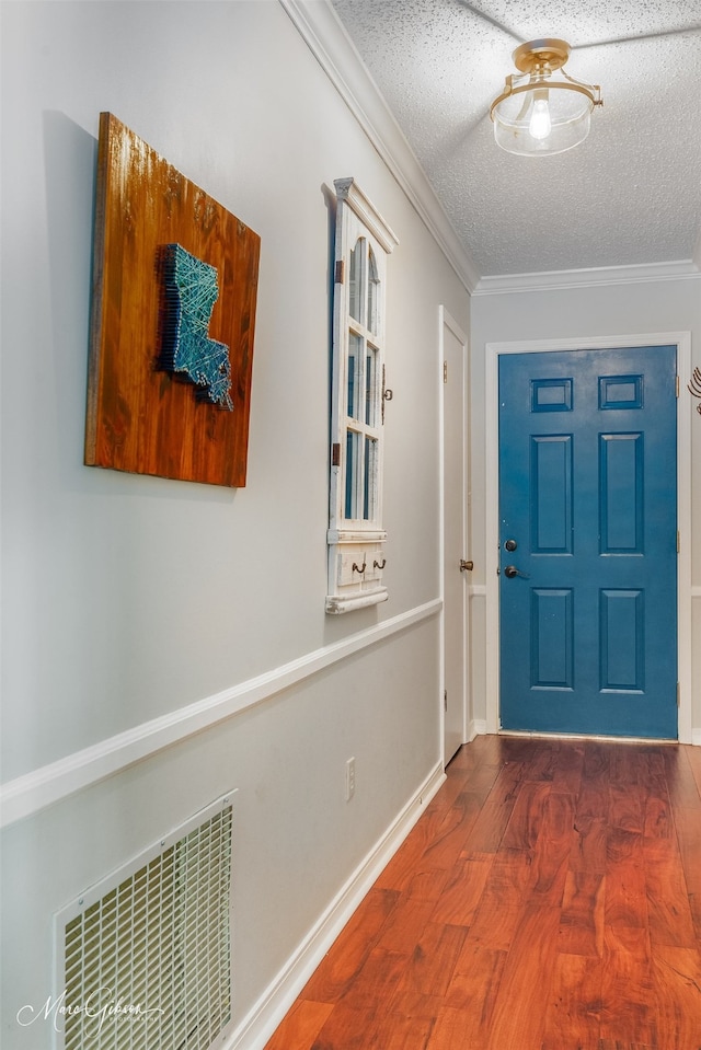 entrance foyer featuring a textured ceiling, crown molding, and dark wood-type flooring