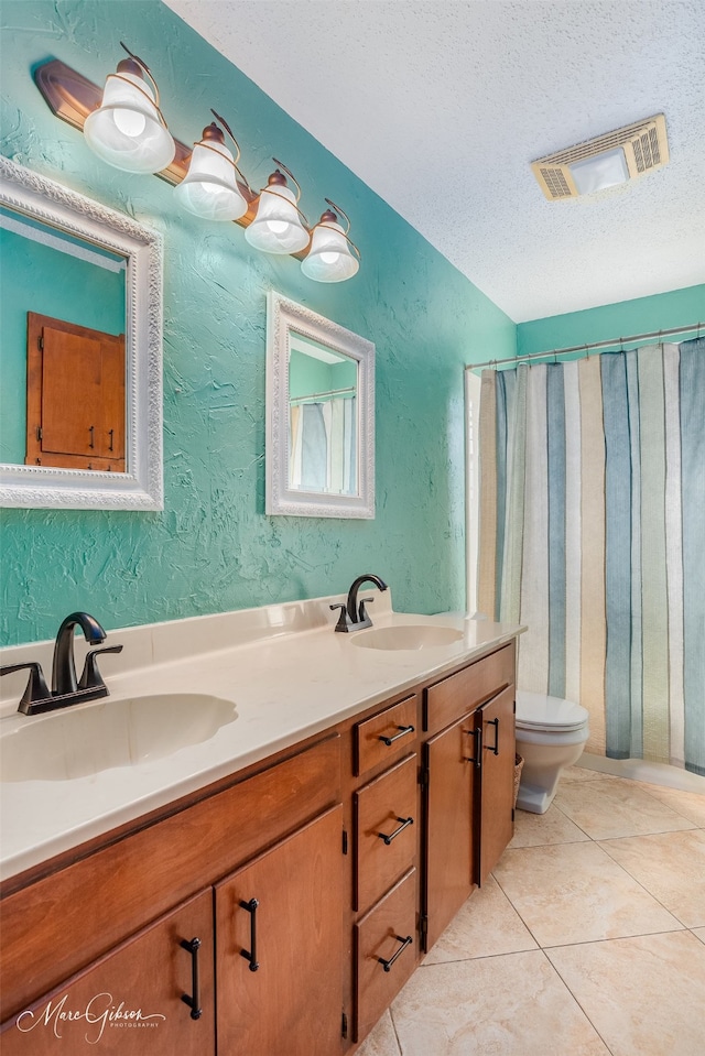 bathroom featuring a textured ceiling, vanity, tile patterned floors, and toilet