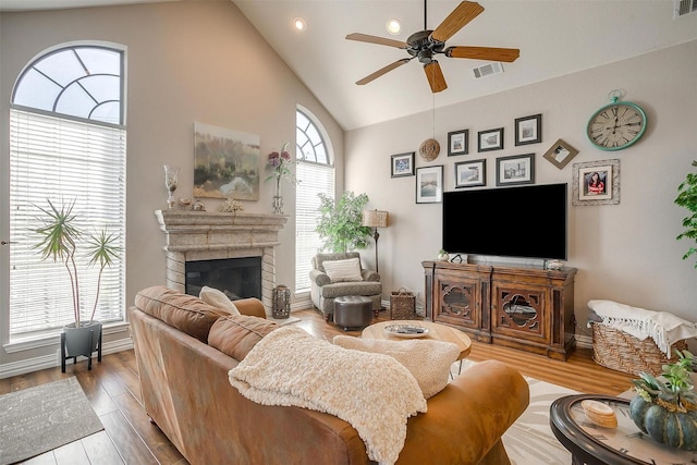 living room with lofted ceiling, a wealth of natural light, ceiling fan, and wood-type flooring