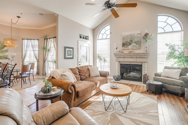 living room with vaulted ceiling, ornamental molding, ceiling fan, and light hardwood / wood-style floors