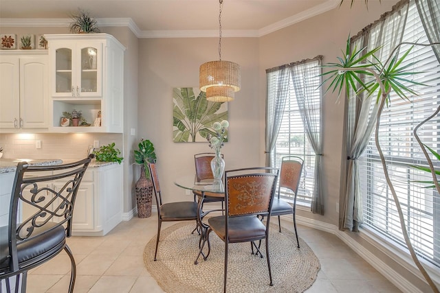 dining room featuring light tile patterned flooring and crown molding