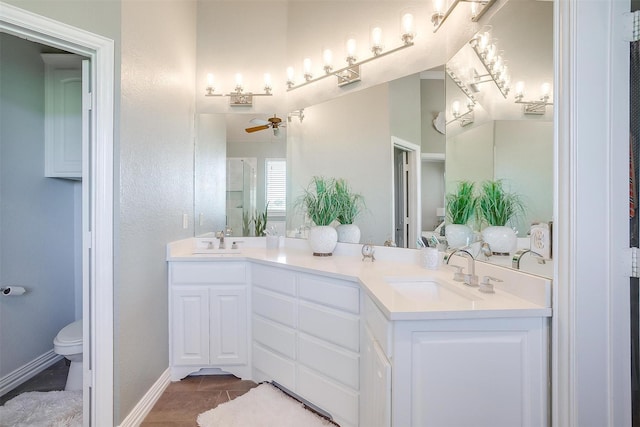 bathroom with toilet, vanity, tile patterned floors, and ceiling fan