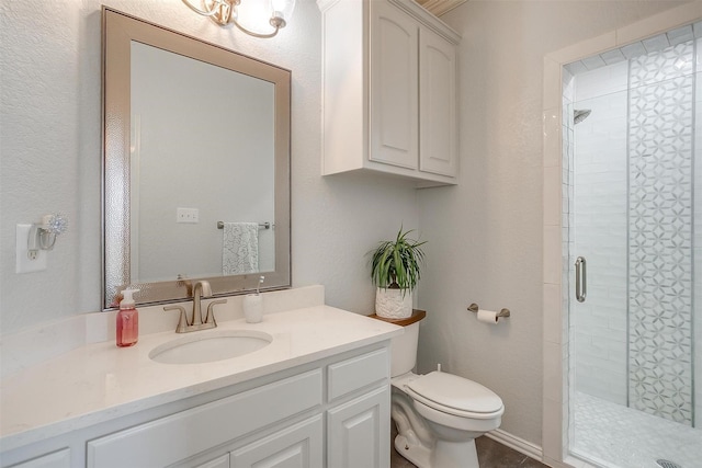 bathroom with vanity, a shower with shower door, and toilet