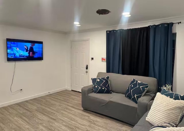 living room featuring wood-type flooring and ornamental molding