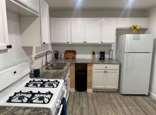 kitchen featuring white appliances, sink, dark stone countertops, and white cabinetry