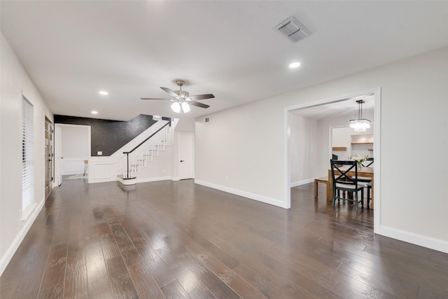 living room featuring ceiling fan with notable chandelier and dark hardwood / wood-style floors