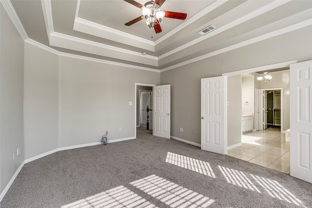 unfurnished room with ceiling fan with notable chandelier, light colored carpet, a tray ceiling, and crown molding