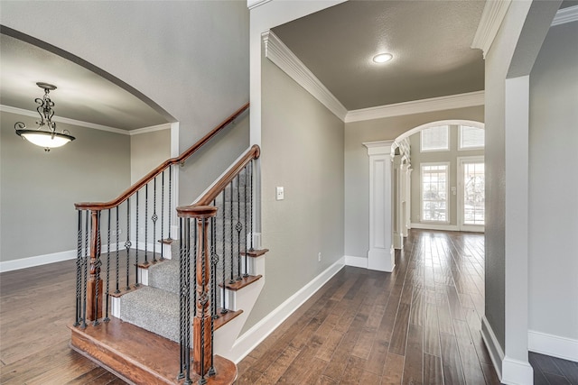 entryway with ornamental molding and dark hardwood / wood-style floors