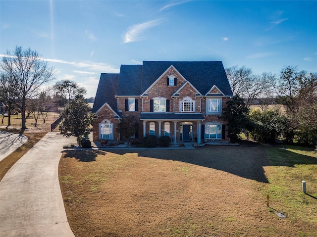 view of front of house with covered porch and a front lawn