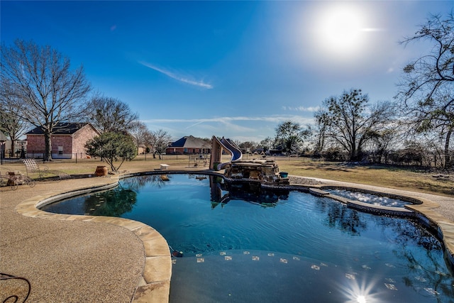 view of swimming pool featuring a water slide, a diving board, a patio area, and an in ground hot tub