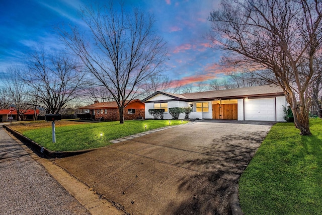 single story home featuring a garage and a yard