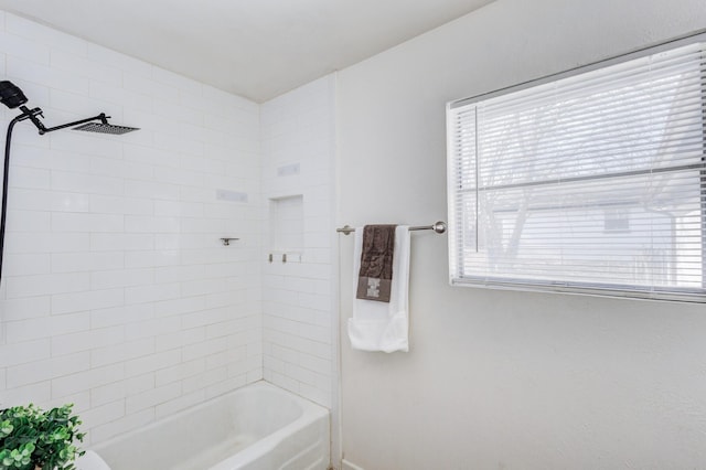 bathroom featuring a healthy amount of sunlight and tiled shower / bath combo