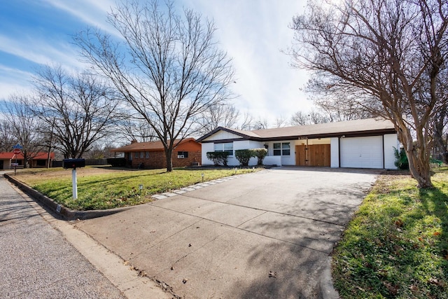 ranch-style home with a garage and a front lawn