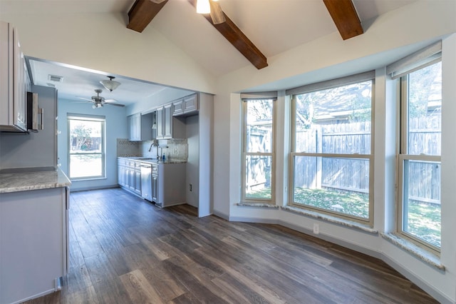 kitchen featuring backsplash, dishwasher, lofted ceiling with beams, and a healthy amount of sunlight