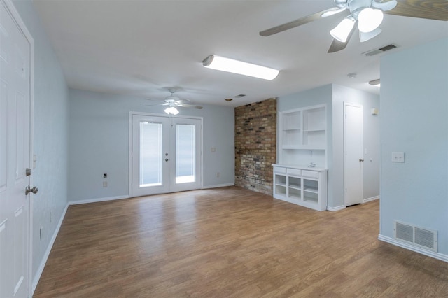 unfurnished living room with french doors, ceiling fan, hardwood / wood-style flooring, and built in features