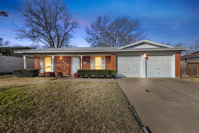 single story home featuring a garage and a yard