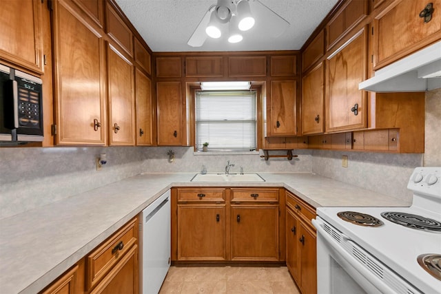 kitchen with white electric range oven, sink, dishwashing machine, ceiling fan, and light tile patterned flooring