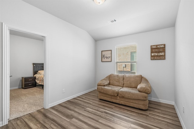 sitting room featuring light wood-type flooring and vaulted ceiling