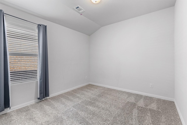 empty room featuring vaulted ceiling and carpet