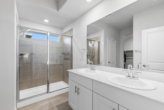 bathroom with an enclosed shower, vanity, and tile patterned floors