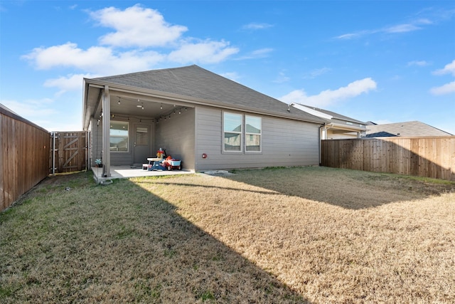 rear view of property featuring a patio and a lawn