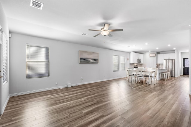 unfurnished living room featuring ceiling fan and wood-type flooring