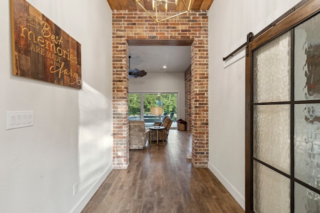 hallway with a barn door and hardwood / wood-style floors