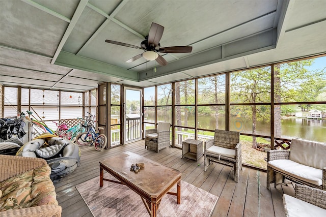 sunroom / solarium featuring ceiling fan and a water view