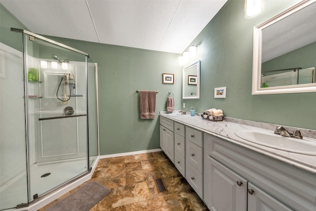 bathroom featuring an enclosed shower, vaulted ceiling, a textured ceiling, and vanity