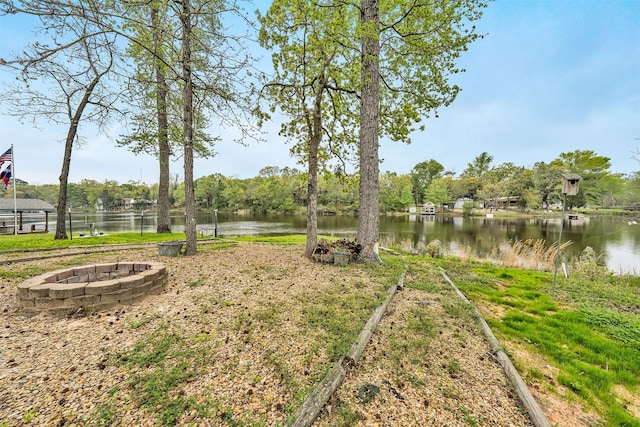 view of yard featuring a fire pit and a water view