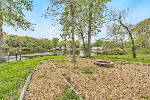 view of yard with a fire pit and a water view