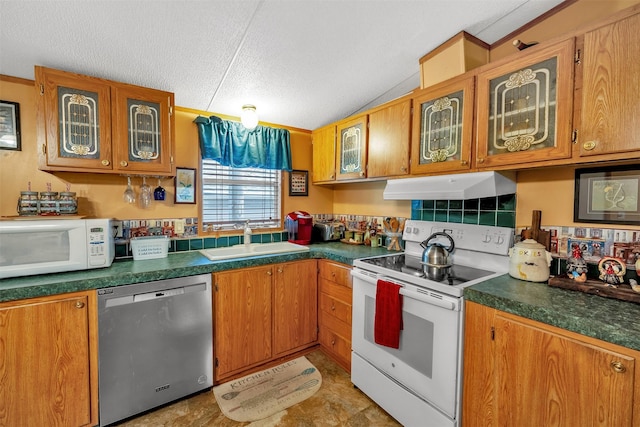 kitchen with white appliances, a textured ceiling, and sink