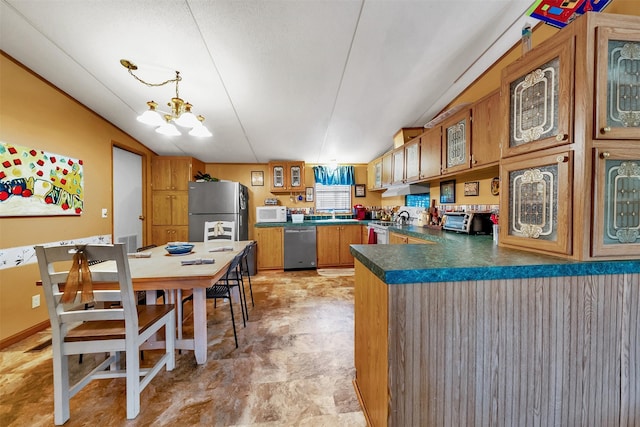 kitchen featuring lofted ceiling, stainless steel appliances, kitchen peninsula, and a chandelier