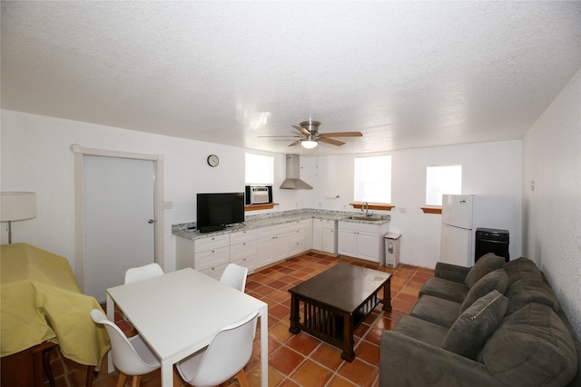 living room with a textured ceiling, a ceiling fan, and tile patterned flooring