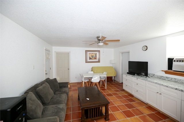 living room with a textured ceiling and ceiling fan