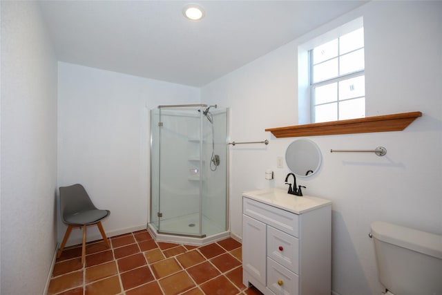 bathroom featuring toilet, vanity, baseboards, and a stall shower