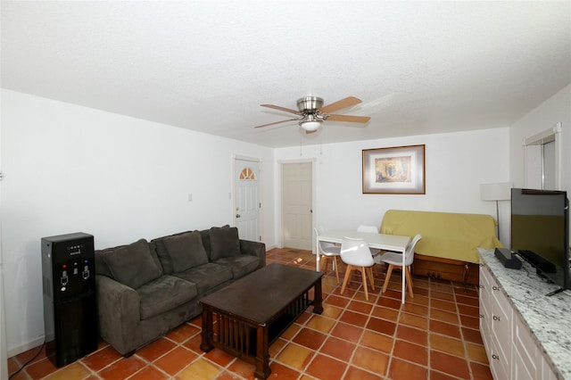 living room with tile patterned flooring, ceiling fan, and a textured ceiling