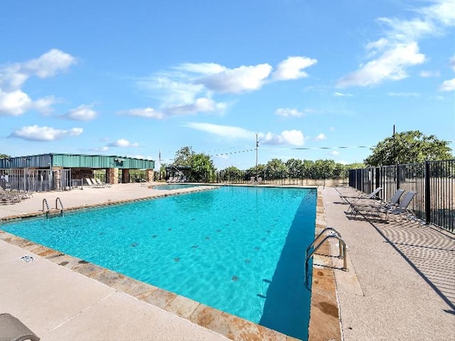 pool with a patio and fence