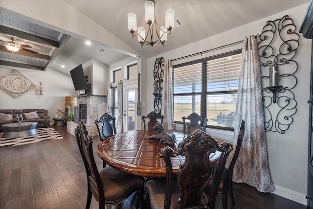 dining area with lofted ceiling with beams, dark wood-style flooring, a fireplace, and baseboards