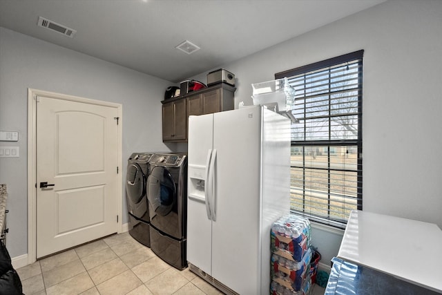 laundry area with cabinet space, visible vents, baseboards, washing machine and dryer, and light tile patterned flooring