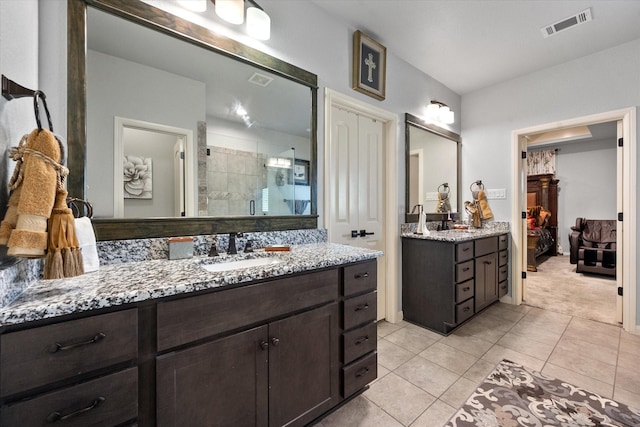 full bathroom with visible vents, tile patterned floors, a sink, a shower stall, and two vanities