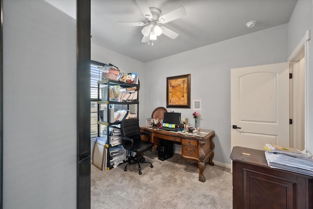 office space featuring light colored carpet, ceiling fan, and baseboards