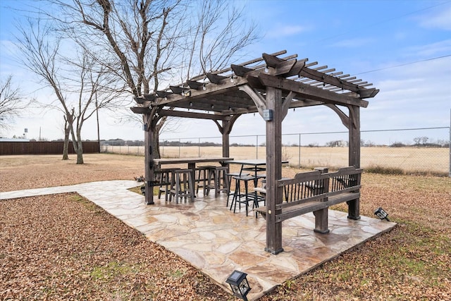 view of home's community with a rural view, fence, a pergola, and a patio