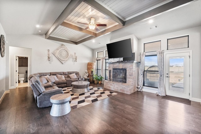 living room featuring dark wood-type flooring, vaulted ceiling with beams, a fireplace, and baseboards