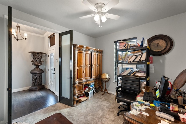 carpeted home office with crown molding and ceiling fan with notable chandelier