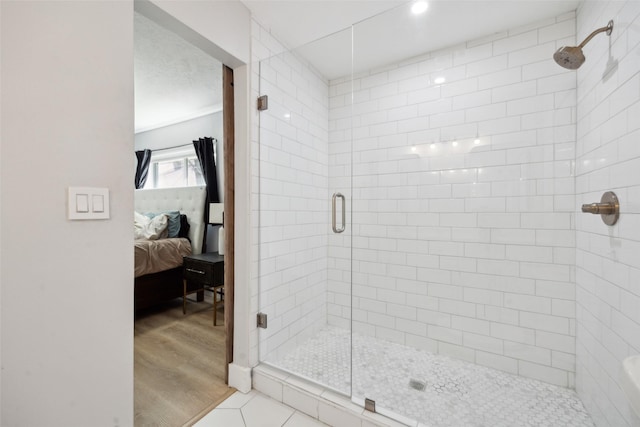 bathroom with an enclosed shower and tile patterned floors