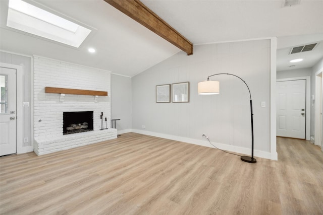 unfurnished living room with lofted ceiling with skylight, a brick fireplace, and light wood-type flooring