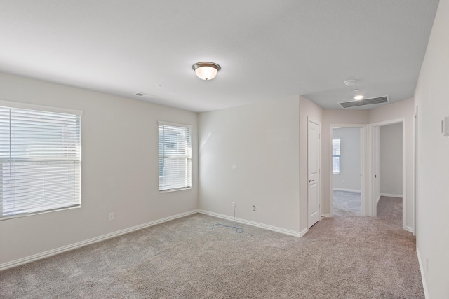 unfurnished room featuring light carpet